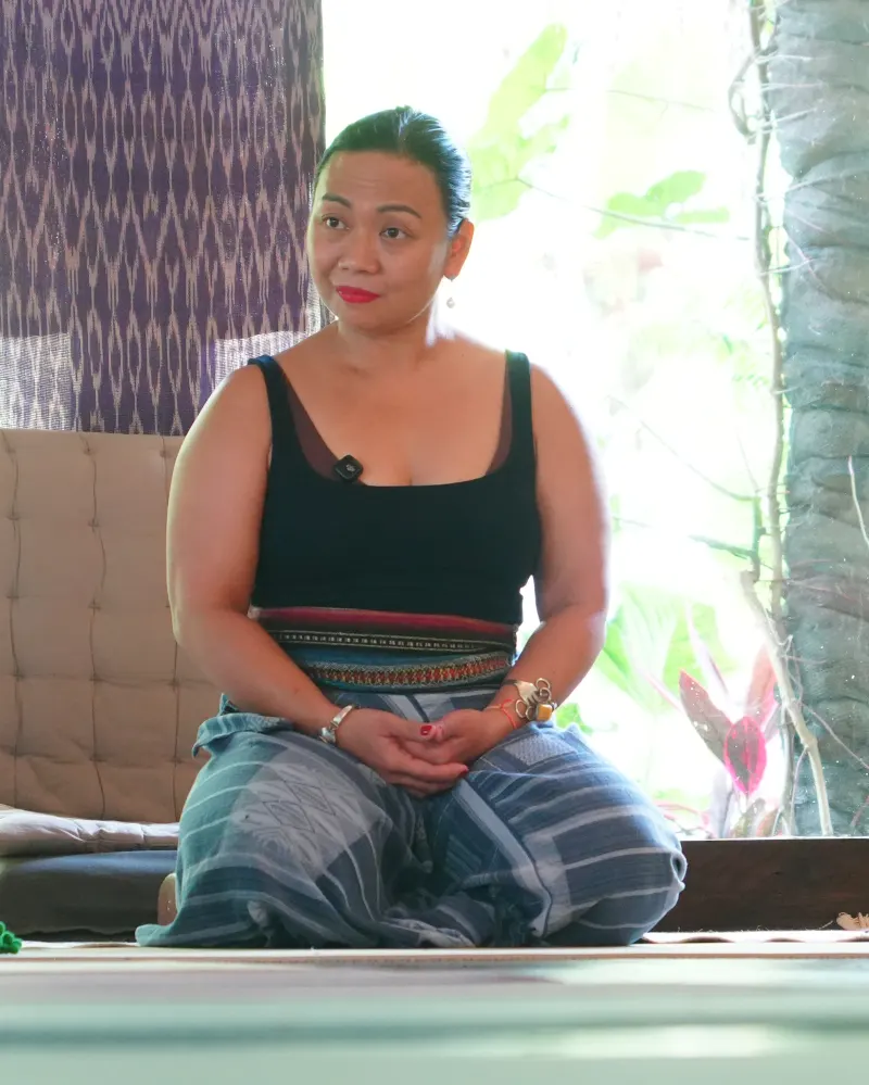 Rina Loy seated calmly by a bright window during a session